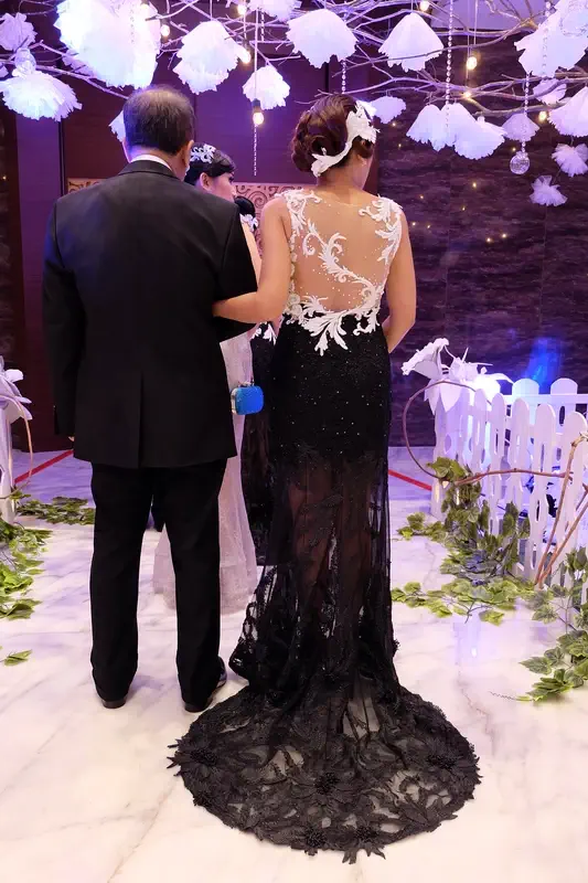Tampak belakang Gaun Mama Pengantin elegan warna putih dengan rok hitam. Gaun Karya Fifilia.