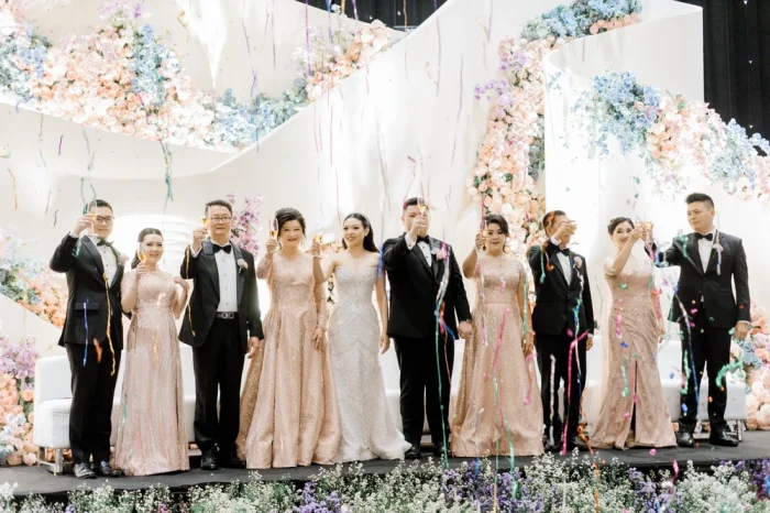 Foto keluar besar lengkap pasangan mempelai dengan orang tua masing-masing dan saudara kandung. Gaun Mama Pengantin dan gaun pesta saudari perempuan karya Fifilia.